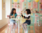 Two children sitting at a table in a colorful playroom.