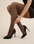Black sheer with gold lurex shimmer tights with black high-heeled shoes on a neutral background