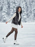 Woman ice skating in a snowy landscape wearing a dark fur vest and white outfit.