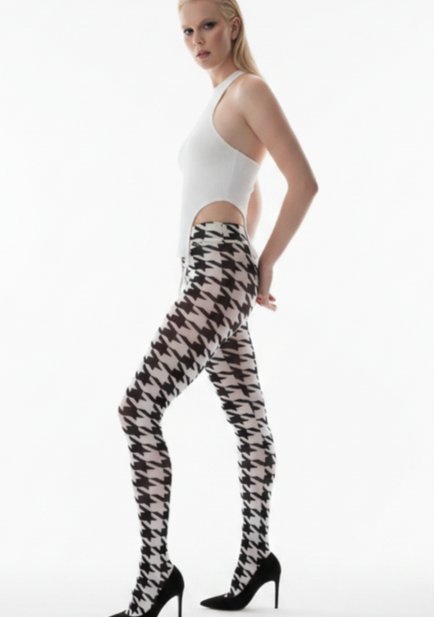 Woman wearing a white top and houndstooth patterned tights on a white background
