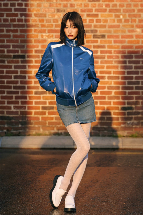 White micro-fishnet tights paired with a denim mini skirt, blue track jacket, and white loafers, Ambra Micro-Fishnet Tights.