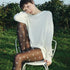 Woman sitting outdoors wearing a sheer white top and polka dot tights.