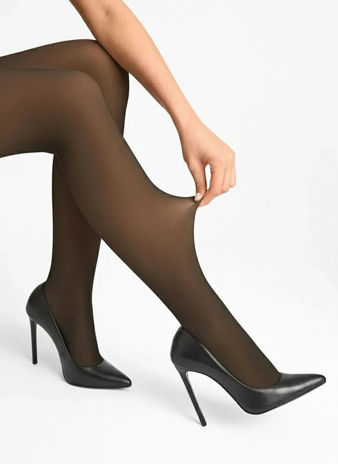 Person wearing black high-heeled shoes with a close-up of tights, branded 'Efecto Ganchillo'.