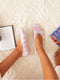 Person wearing pink striped socks on a carpeted floor with books nearby