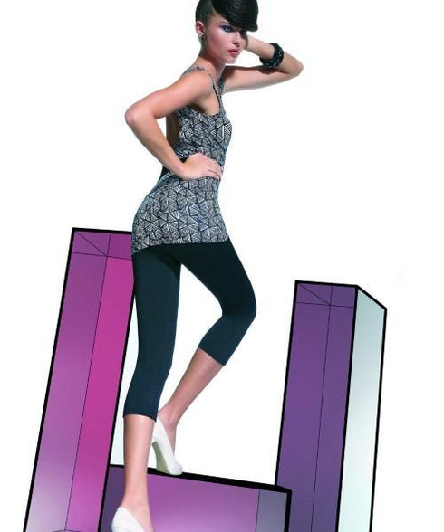Nina Capri Leggings, black capri leggings worn with a geometric patterned top and white shoes, posed against colorful geometric shapes.