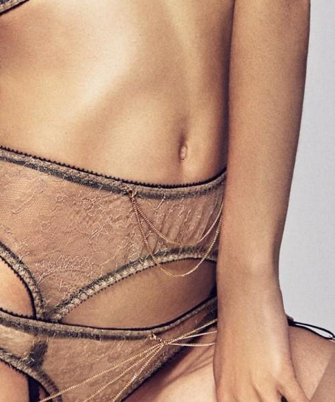 Gold-plated suspender chain in Gold. Delicate chains draped over sheer lace lingerie.