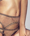 Gold-plated suspender chain in Gold. Delicate chains draped over sheer lace lingerie.
