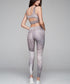 High-waisted leggings and a matching crop top feature a gray and white snake print pattern.