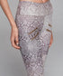 Close-up of leggings with a light gray snake print pattern and gold zipper details on thighs.